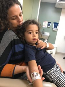 Foto mostrando filho no colo da mãe após precedimento médico